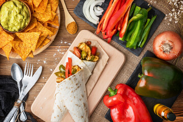 Chicken fajitas with peppers, onion and spices and guacamole sauce with tortilla chips or nachos on...