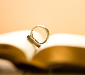 Two wedding rings on a bible page.