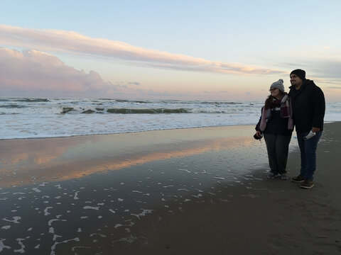 Smiling couple standing on beach in autumn, Marina di Ginosa, Ginosa, Taranto, Puglia, Italy