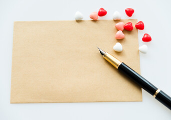 blank note card and pen surrounded by heart shape candy