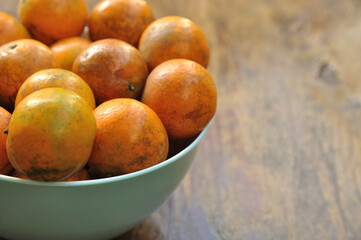Close up of Tangerine, Mandarin, Oranges in a Bowl on wood table