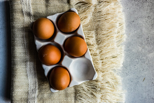 Overhead view of eggs in a ceramic egg carton