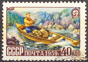 USSR-CIRCA 1959: A stamp printed in the USSR, shows a man in a wooden boat, circa 1959