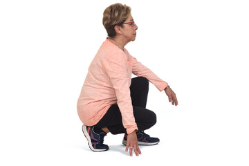 side view of aserious  senior woman squatting on white backgrond