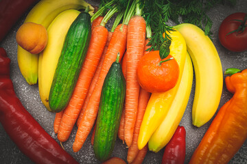 Seasonal vegetables and tropical fruits: cucumber, carrot, pepper, banana, tangerine and apricot.