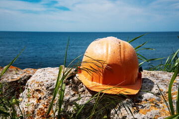 Construction helmet of a geologist on the background of a sea landscape. Excavations in the...