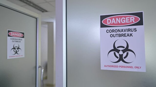 Alert notice paper on the door of danger coronavirus outbreak with biohazard symbol and authorized personnel only in the hospital