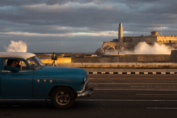 Old car on Malecon street of Havana with storm clouds in background. Cuba