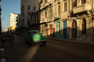 Naklejka na ściany i meble Amazing old american car on streets of Havana with colourful buildings in background. Havana, Cuba.