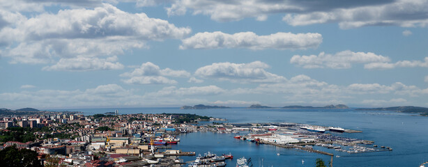Vista general del puerto de Vigo y su ciudad ,y las Islas Cíes de fondo con un cielo azul con nubes