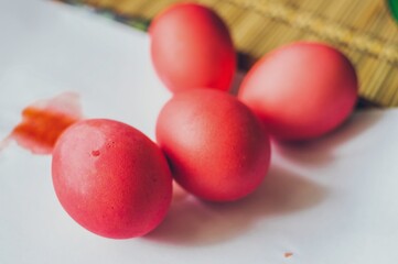 Bright red painted Easter eggs on white paper ready for holiday