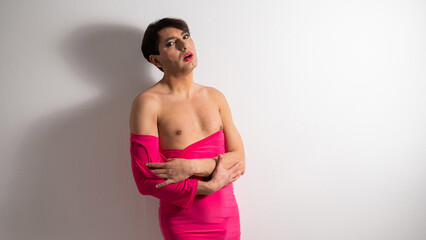 Fototapeta na wymiar Homosexual in a pink female dress. A man in make-up.