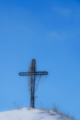 Wayside cross on a snowy mound during the Canadian winter in Quebec
