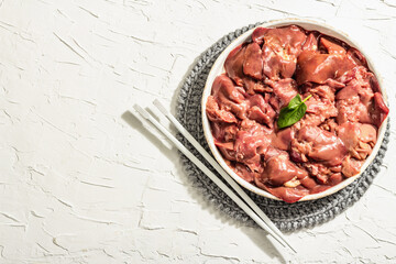 Raw chicken liver in a bowl. Fresh food ingredient and spices, trendy hard light, dark shadow