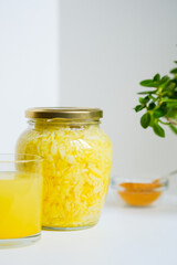 Fermented cabbage with turmeric. Cabbage kvass. Pickling vegetables without salt. Fermentation. Vitamin treatment and nutrition. Organic turmeric powder and green leaves of houseplant in a frame.