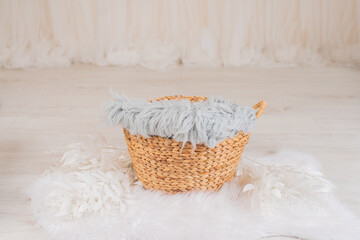 Fototapeta premium A basket for a newborn baby with white flowers in a photo studio