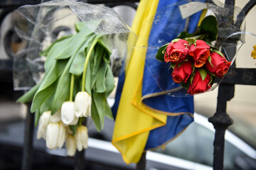 Flowers, candles and banners with different messages are seen on the fence of the Ukraine embassy...