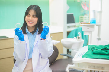 Young female dentist holding invisalign in dental clinic, teeth check-up and Healthy teeth concept