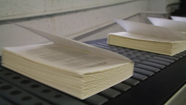Brand New Books Fresh From Printer coming off of conveyer Belt At Publishing Factory