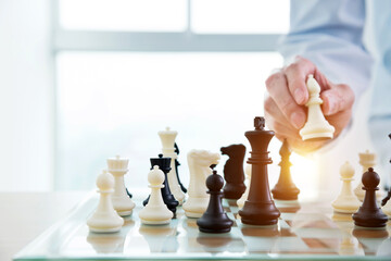 Businessman playing chess on board in office