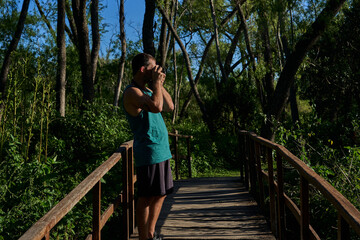Naklejka premium young man photographing in nature with vintage camera