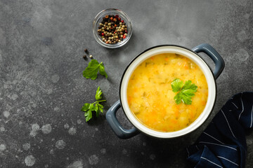 Creamy vegan split pea soup in pot on dark background. Copy space.