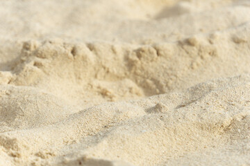 Fototapeta na wymiar Beach sand close-up. Small blurry sand dunes.