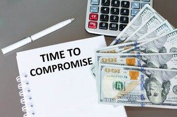 TIME TO COMPROMISE text on notepad next to calculator and money