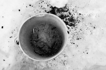 Metal bucket for ashes from the stove in the snow.