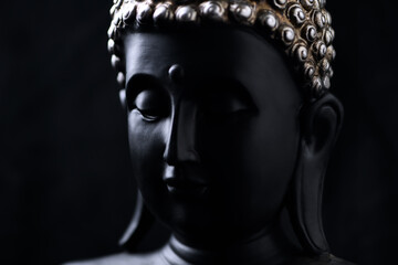 Meditating Buddha Statue on black background. Close up. 