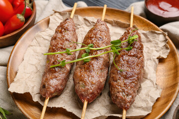 Plate of skewers with tasty lula kebab on table, closeup