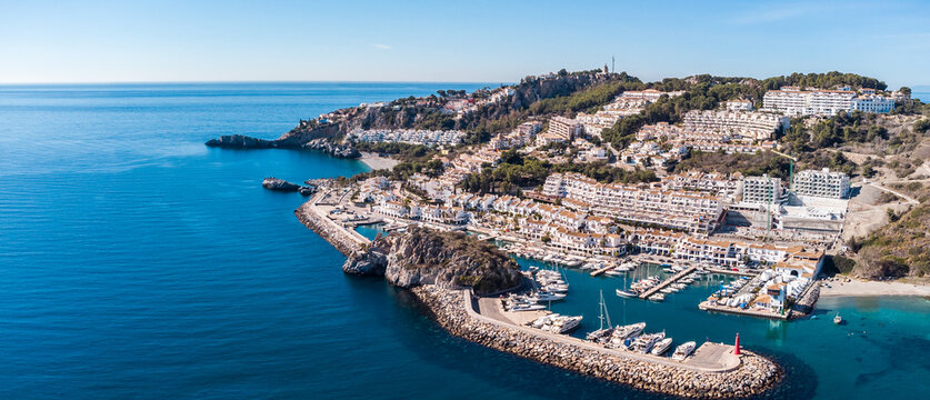 Aerial perspective of La Herradura city,Granada, Spain. Beautiful coastal city situated in south of Spain. View of the port and luxury urbanisation on hills. Mountains in background. Luxury real estat