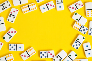 Domino on a yellow background with copyspace for text.