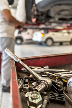 Latin male mechanic fixing an automobile brake system in a workshop