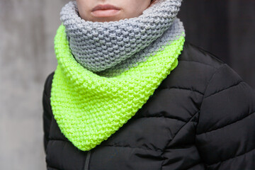 Hand made designed knitted snood scarf on a girl's neck
