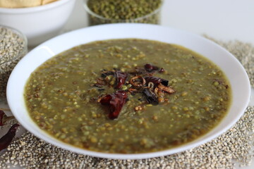 One pot dish with pearl millet and moong, seasoned with red chillies and curry leaves. Commonly known as Bajra kichadi. Served with fried papads