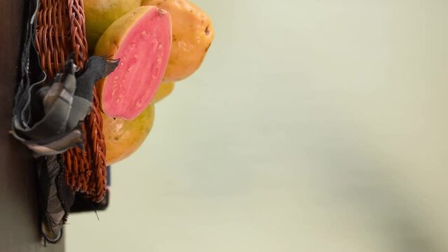 Vertical video of a hand taking a colombian tropical candy made of guava called bocadillo on black wooden table 