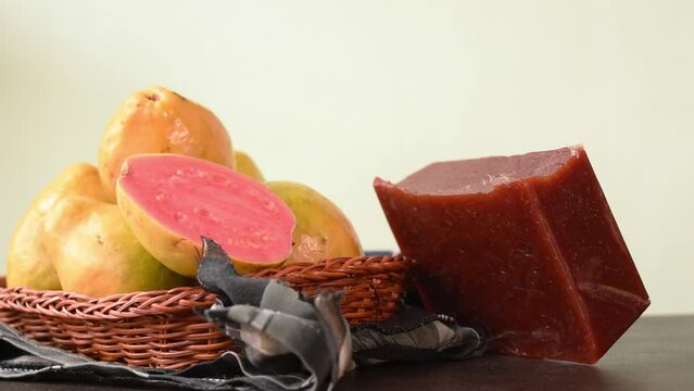 Hand leaving a colombian tropical candy made of guava called bocadillo on black wooden table 