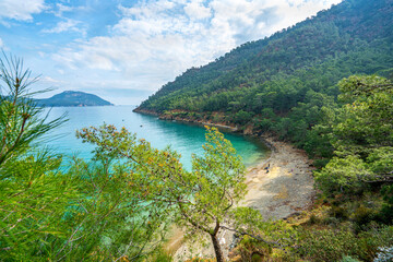 Fototapeta na wymiar The Bay of Adrasan extends along more than 2.5 km of Antalya, naturally protected area, surrounded by a national park with pine forests, Taurus Mountains, blue water lagoons and sandy beaches.