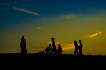 Fototapeta na wymiar 夕暮れの丘と人々のシルエット