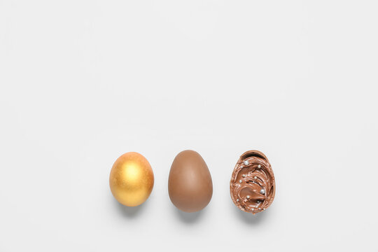 Delicious chocolate eggs with paste filling on light background