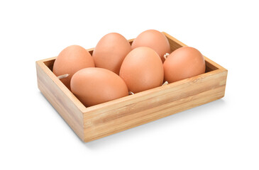 Wooden box with brown eggs on white background