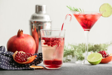 Glasses of tasty pomegranate cocktail on table