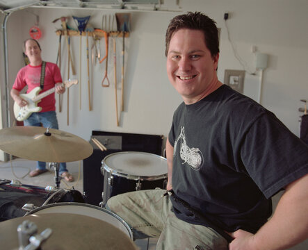 Portrait Of Middle Aged Male Drummer In Garage Band 