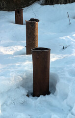 Rusty metal pipes sticking out of the snow