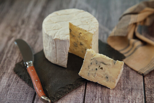 Portion of delicious bleu de Bresse cheese on a rustic background
