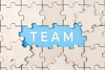 Fototapeta premium Team word on blue background surrounded by puzzle pieces