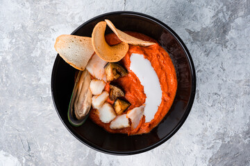 Tomato gazpacho soup with mussels, squid, shrimp in bowl. Seafood, healthy food, close up
