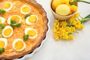 Tasty Easter tart with eggs and narcissus flowers on light background, closeup