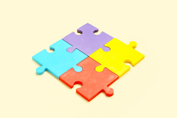 Colorful puzzle pieces on beige background. Concept of autistic disorder